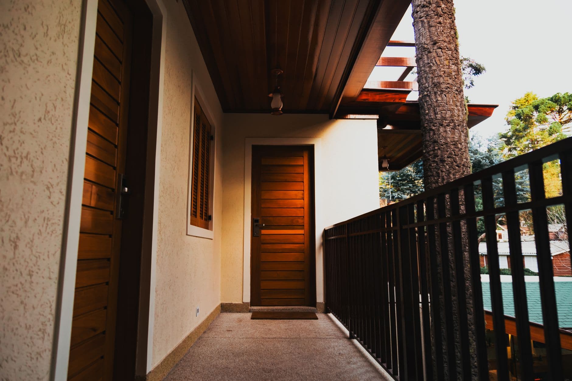 Contemporary apartment balcony featuring wooden doors and railing view.