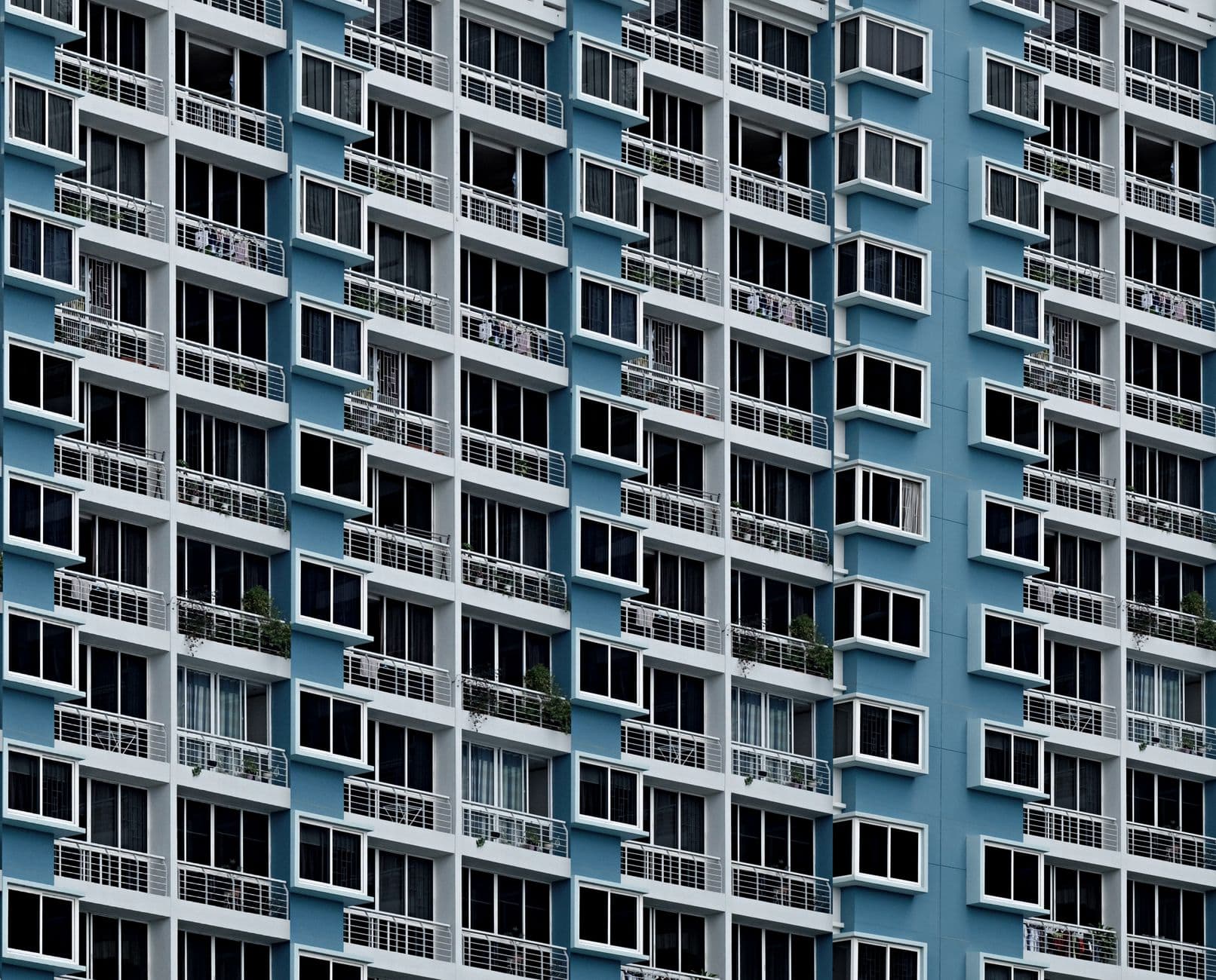 High-rise building facade with repetitive geometric window patterns in Singapore.