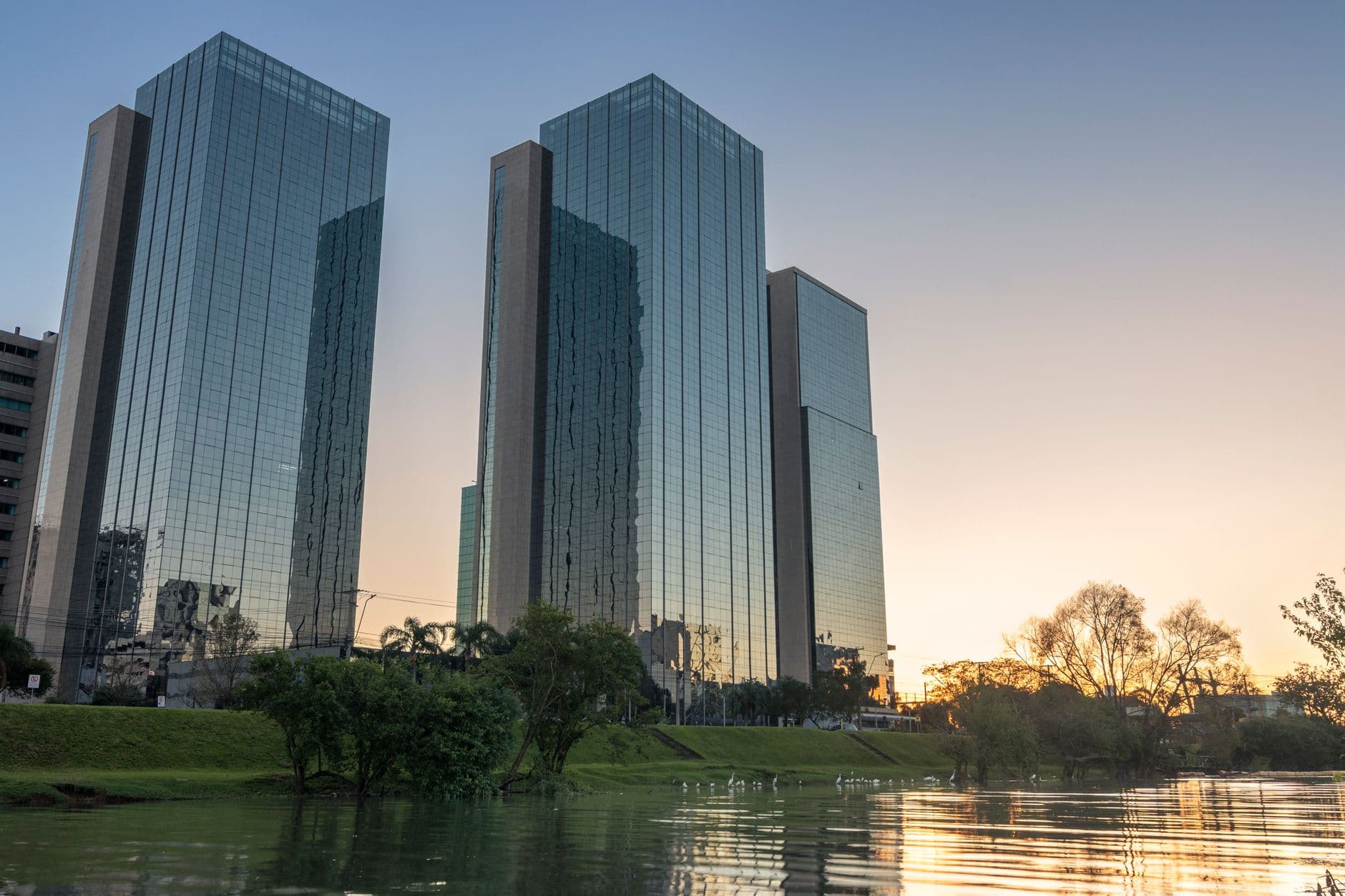 Stunning skyscrapers with glass facades reflecting water and sunset in Rio Grande do Sul, Brazil.