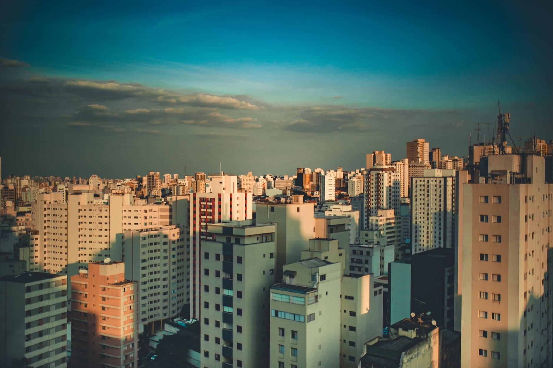 Stunning aerial view of a bustling cityscape with skyscrapers under a clear blue sky.