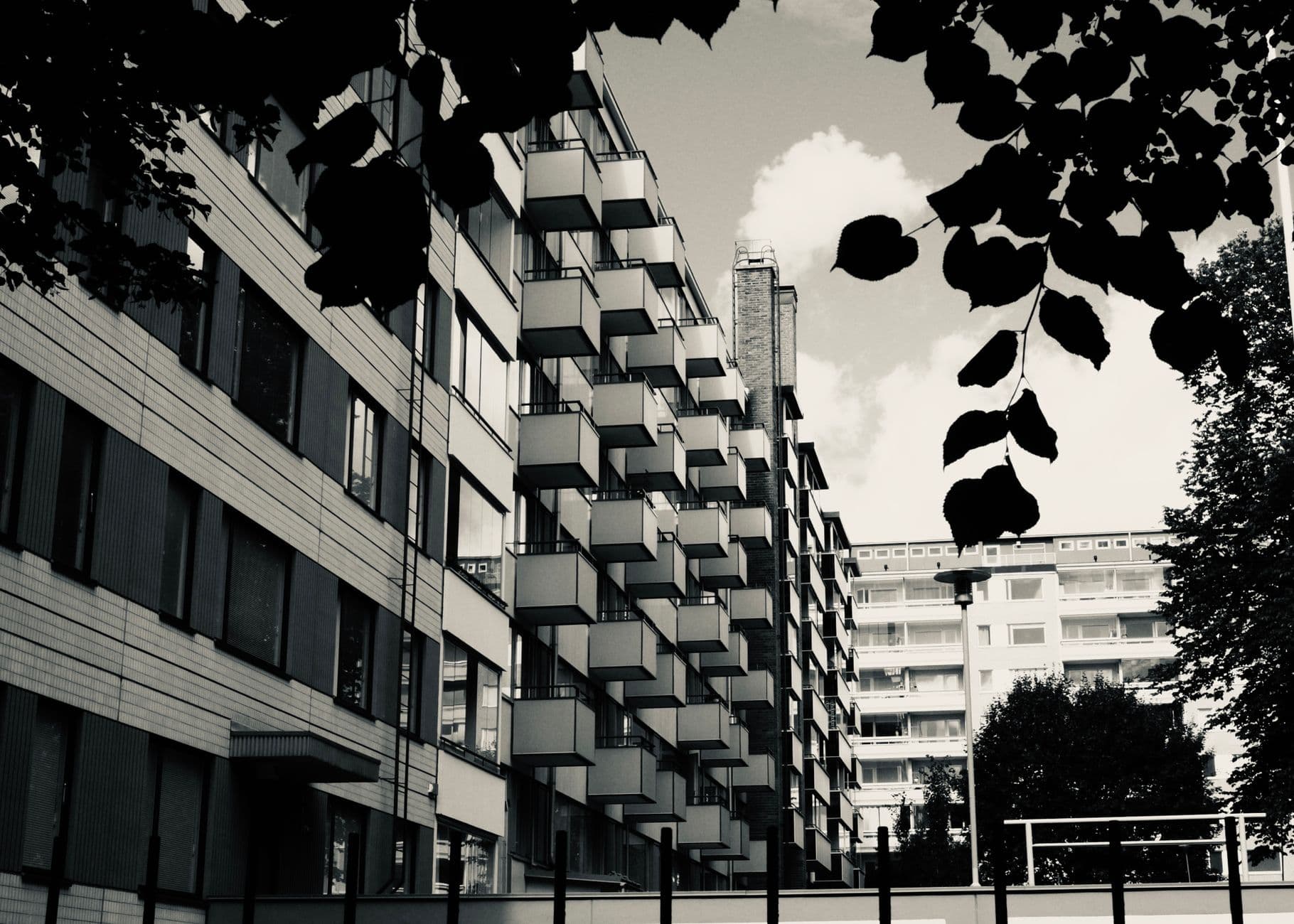 Contemporary residential buildings with distinct geometric balconies in an urban setting.