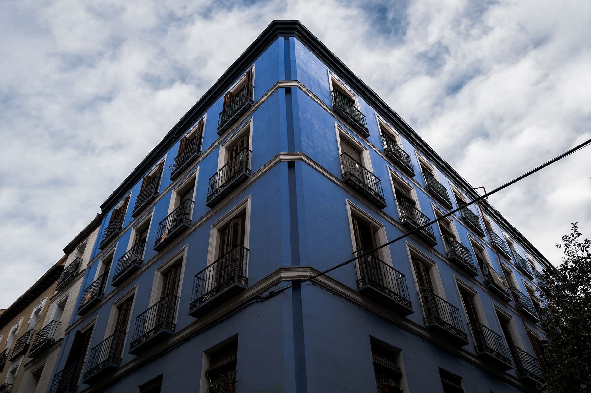 Dramatic angle view of a vibrant blue apartment building in Madrid.