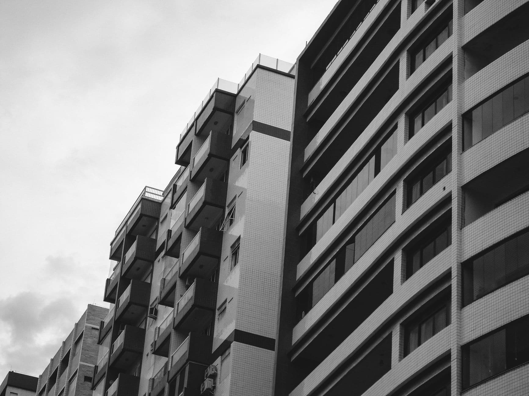 Contemporary urban residential building in black and white low angle exterior view.