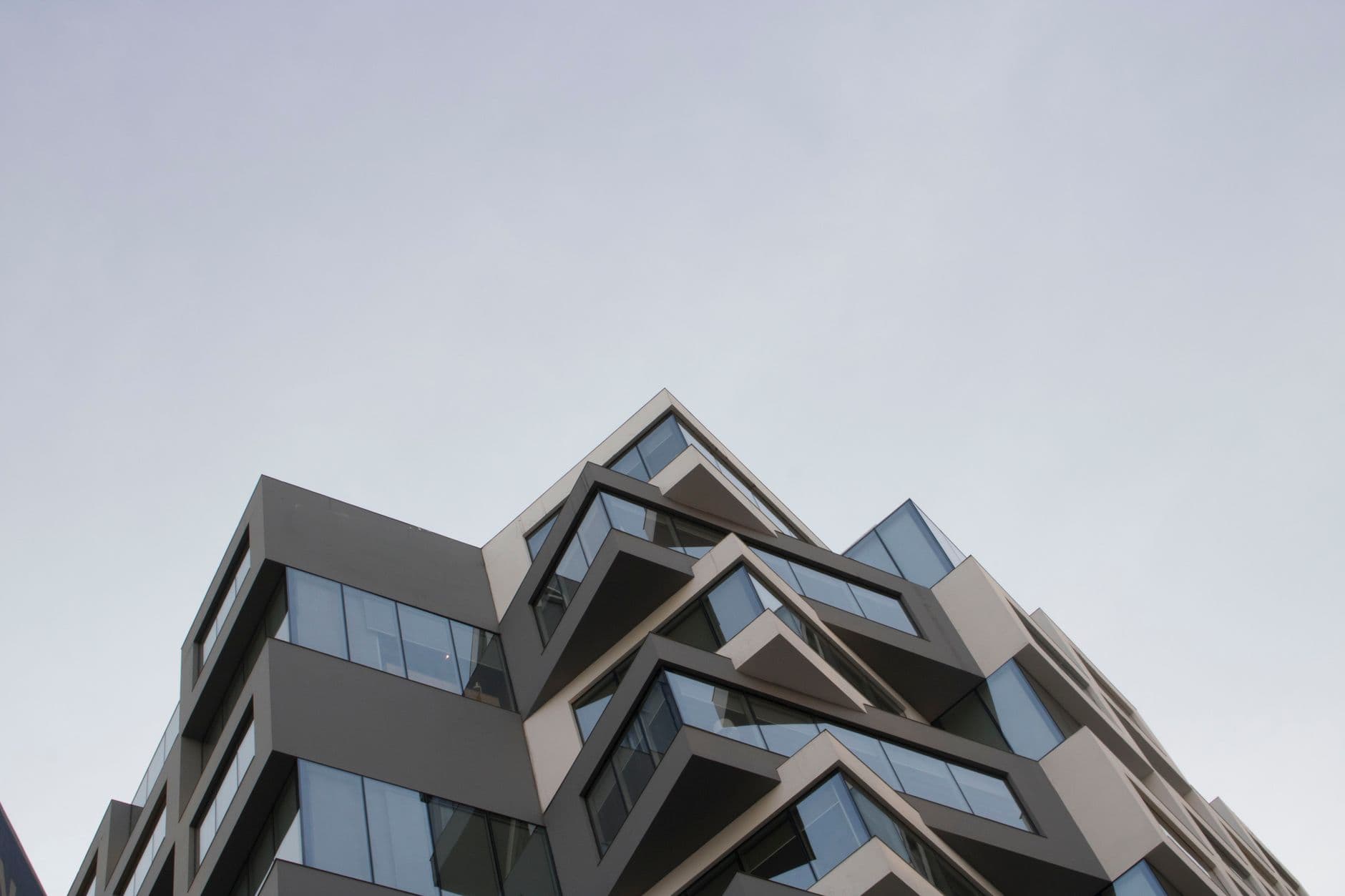 Dynamic modern architecture featuring geometric design under an overcast sky.