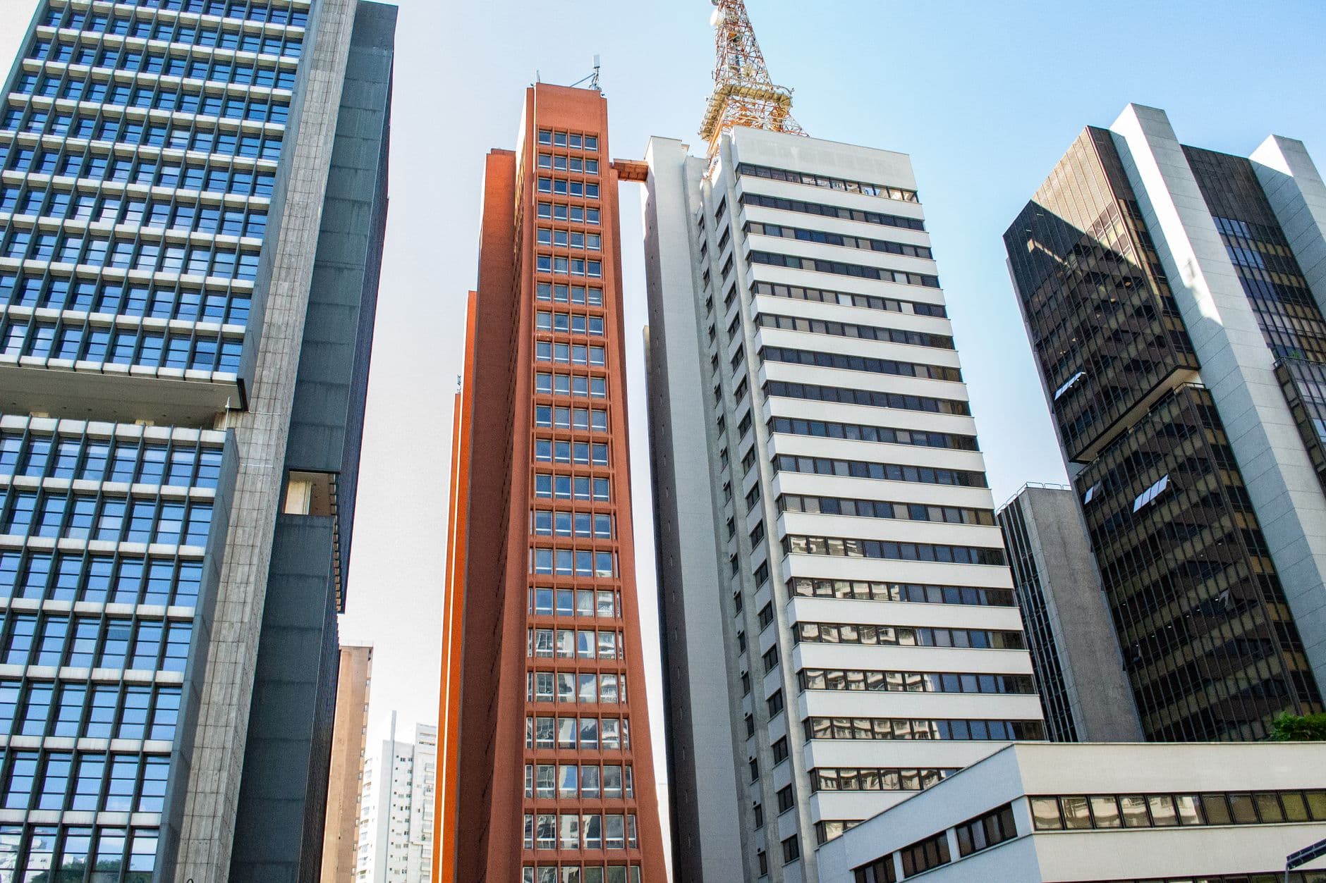 View of modern skyscrapers under a clear blue sky in an urban cityscape.