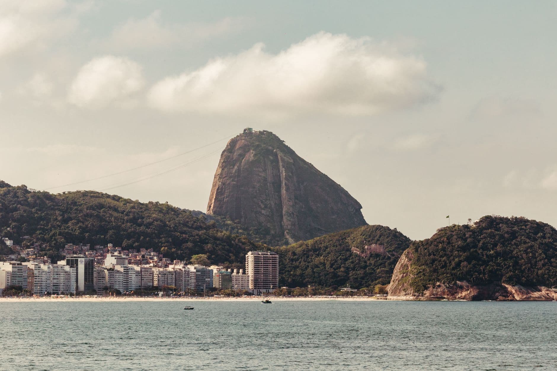 Picturesque view of Sugarloaf Mountain in Rio de Janeiro with the seaside cityscape in the foreground.