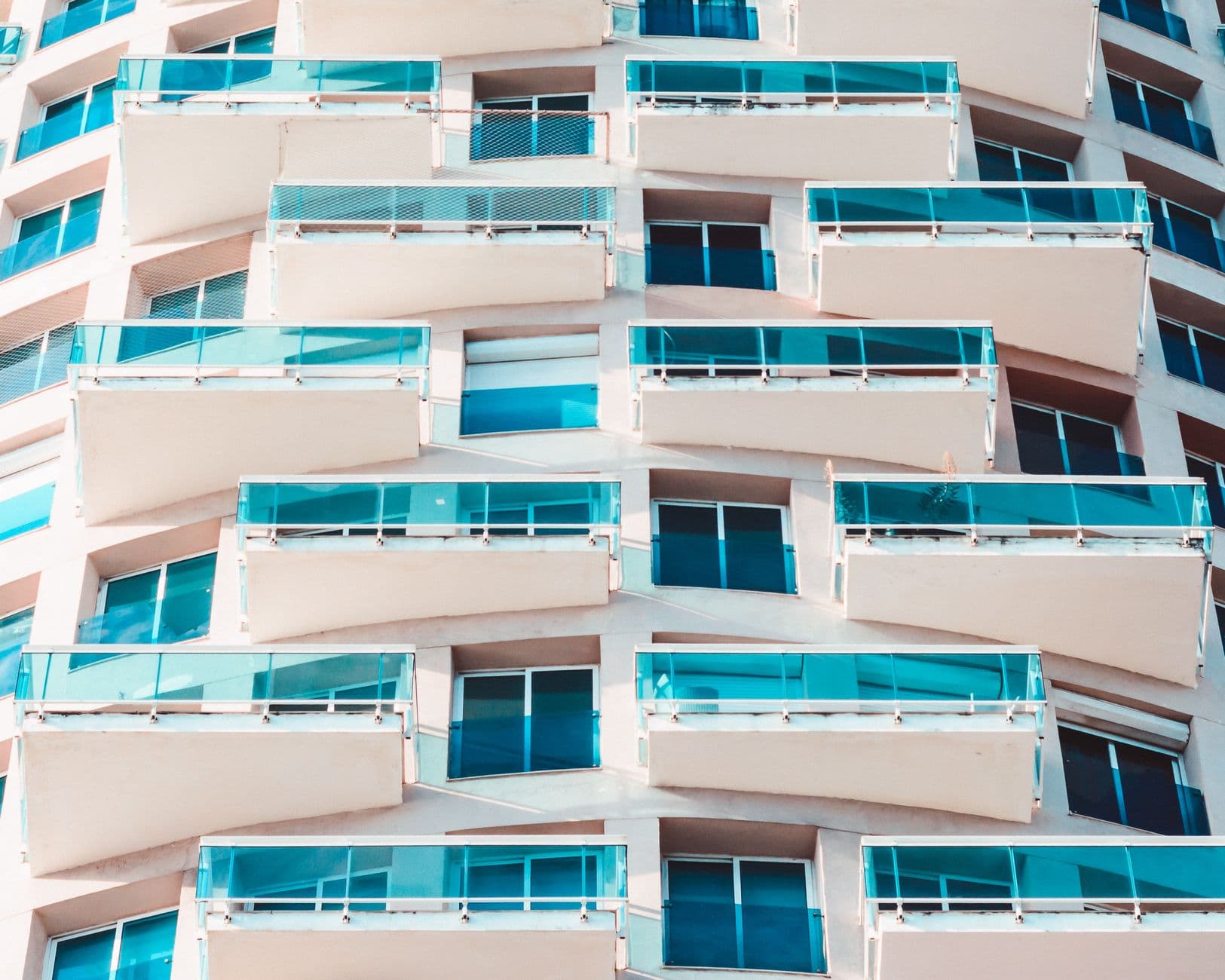 Close-up of a modern building with distinctive glass balconies and geometric design.