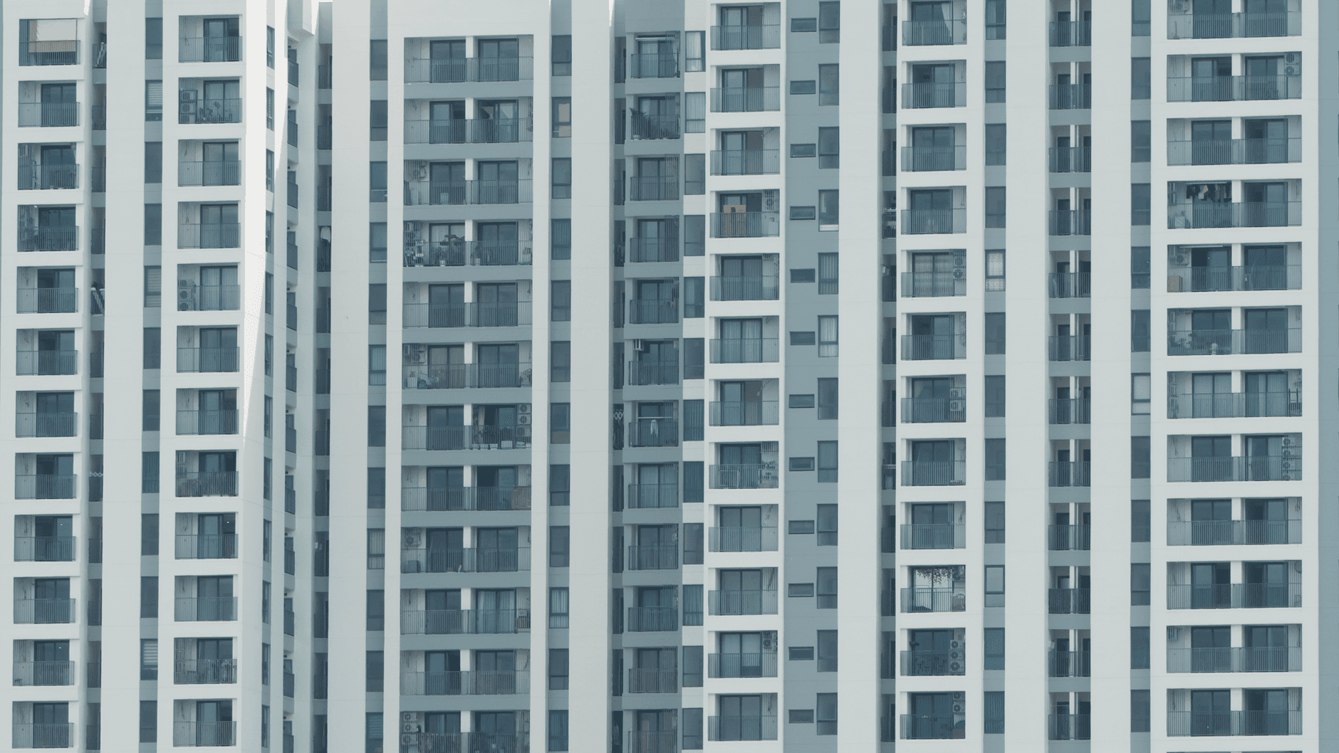 Modern high-rise apartment facade with repetitive pattern and windows.
