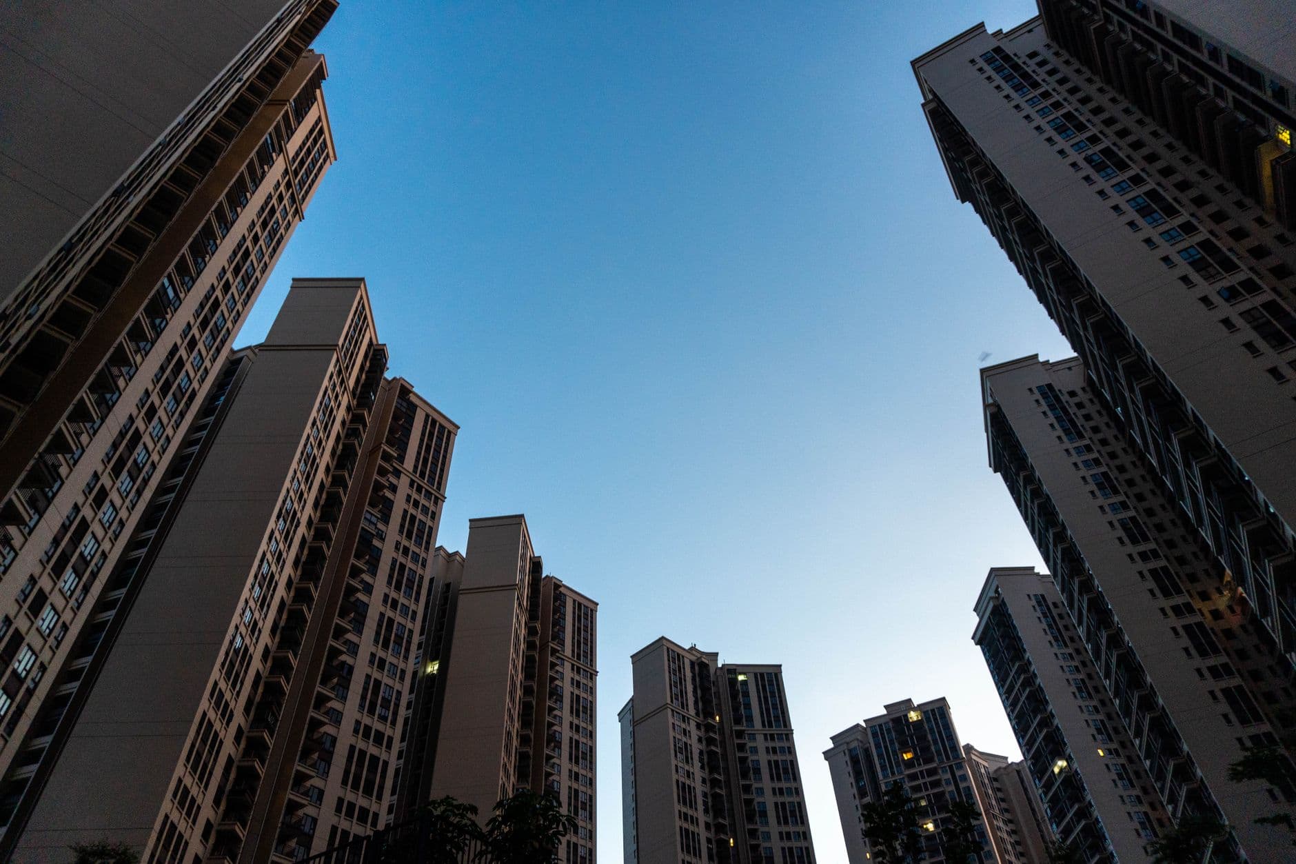 Low angle view of modern skyscrapers against a clear blue sky in an urban setting.