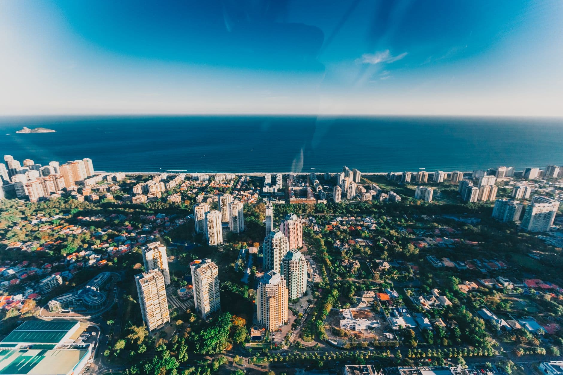 Stunning aerial view of Rio de Janeiro's skyline and ocean horizon under clear skies.