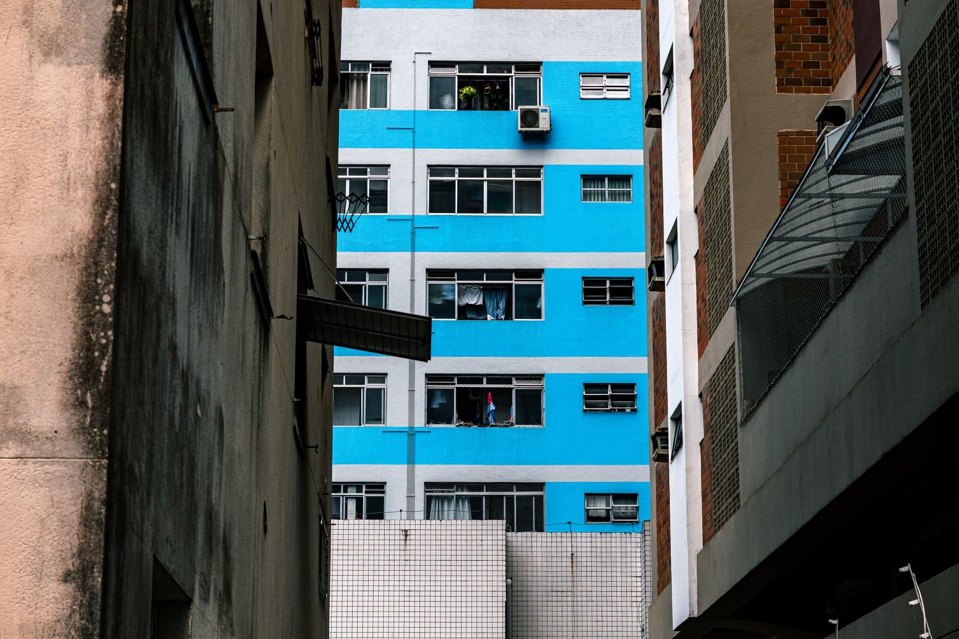 Colorful urban scene with a bright blue building facade surrounded by contrasting structures.
