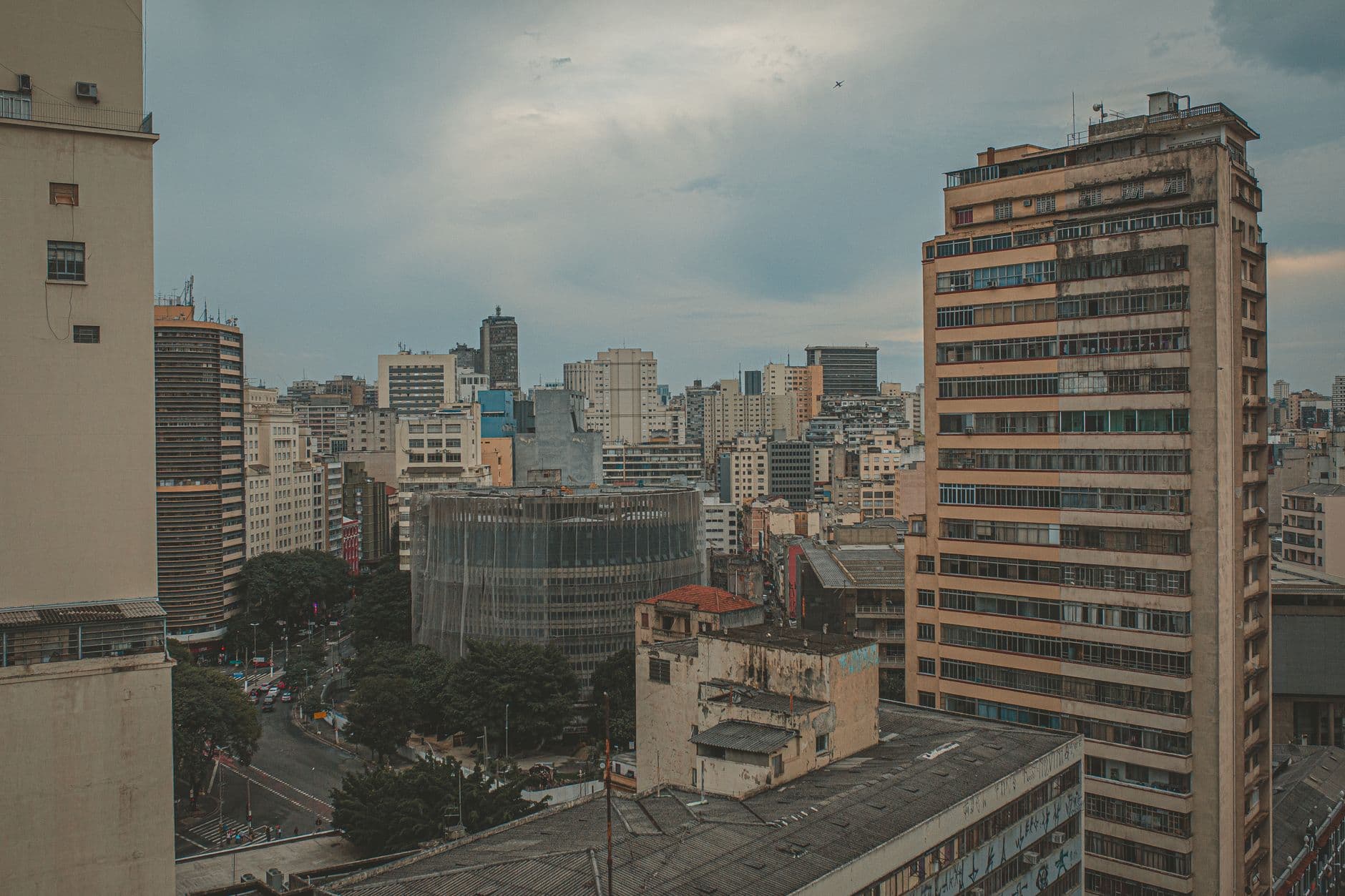 Aerial cityscape showcasing diverse urban architecture with high-rise buildings and cloudy sky.