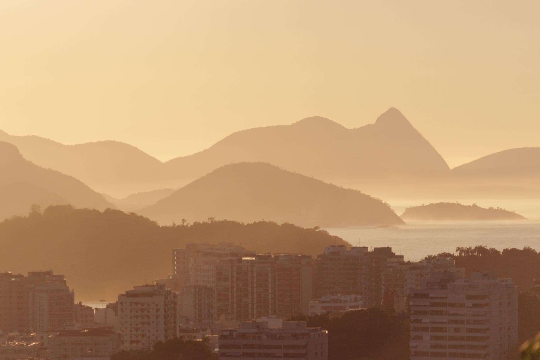 A serene misty morning view of Rio de Janeiro with mountains and cityscape.