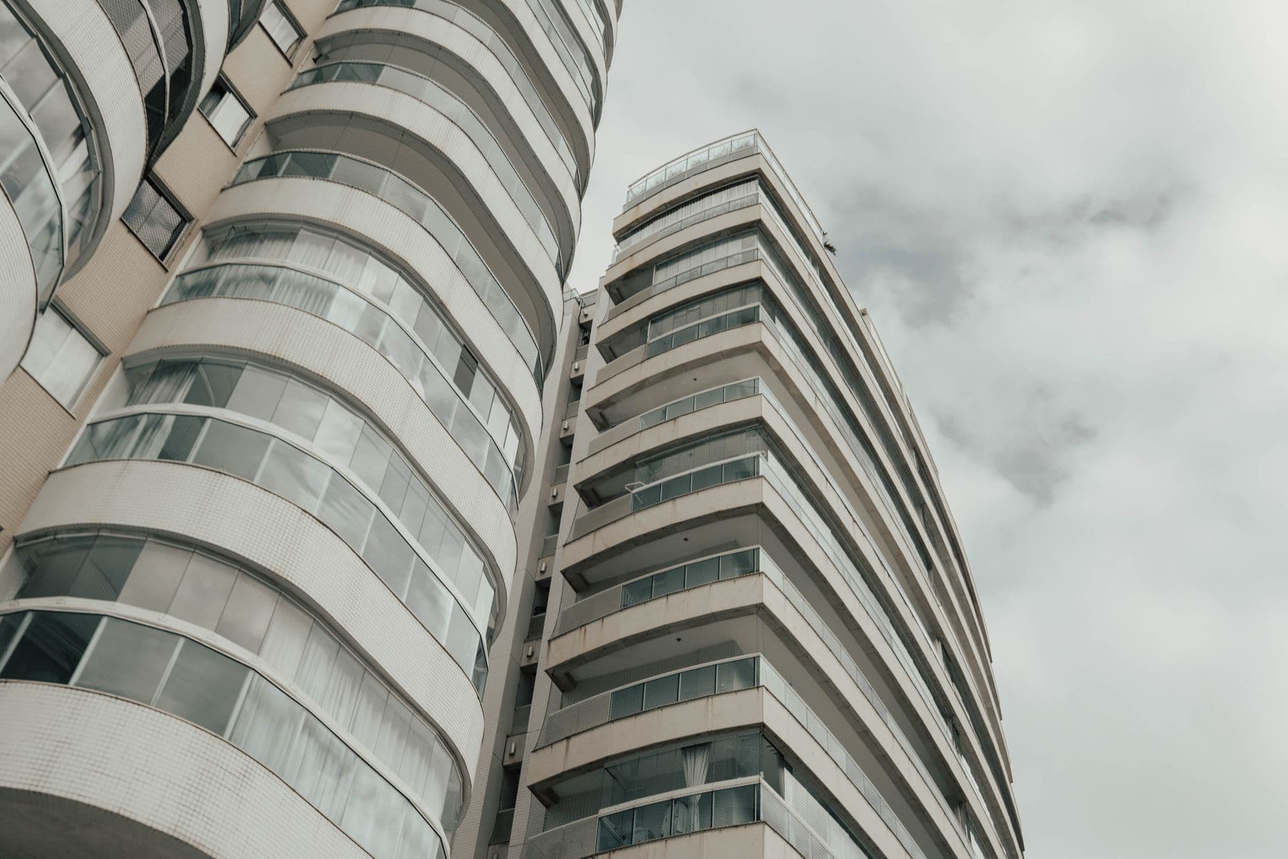 Elevated view of a contemporary high-rise building in Espírito Santo, Brazil, under a cloudy sky.