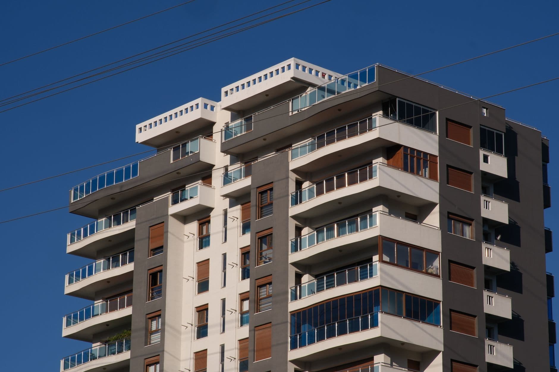 A sleek apartment building under a clear blue sky in İzmir, highlighting contemporary architecture.