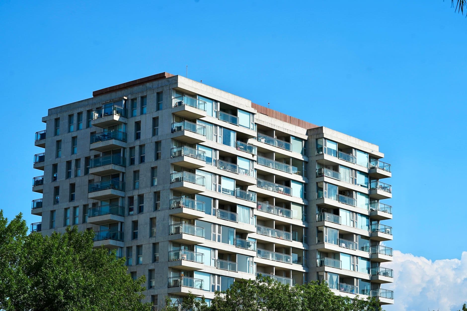 A contemporary apartment building with balconies under a clear blue sky in Tigre, Argentina.