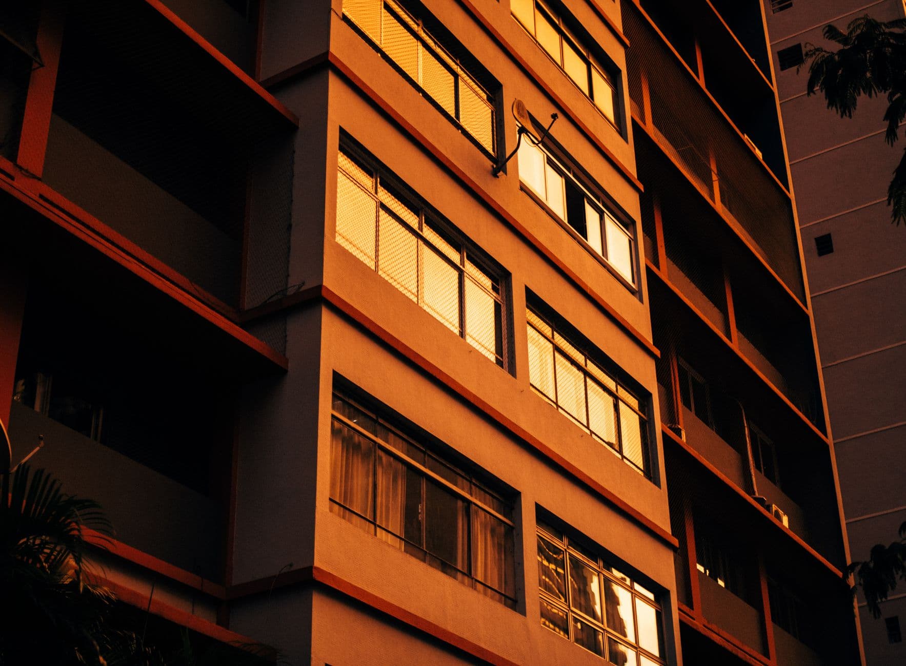 Close-up of a residential building facade illuminated by warm sunset light.