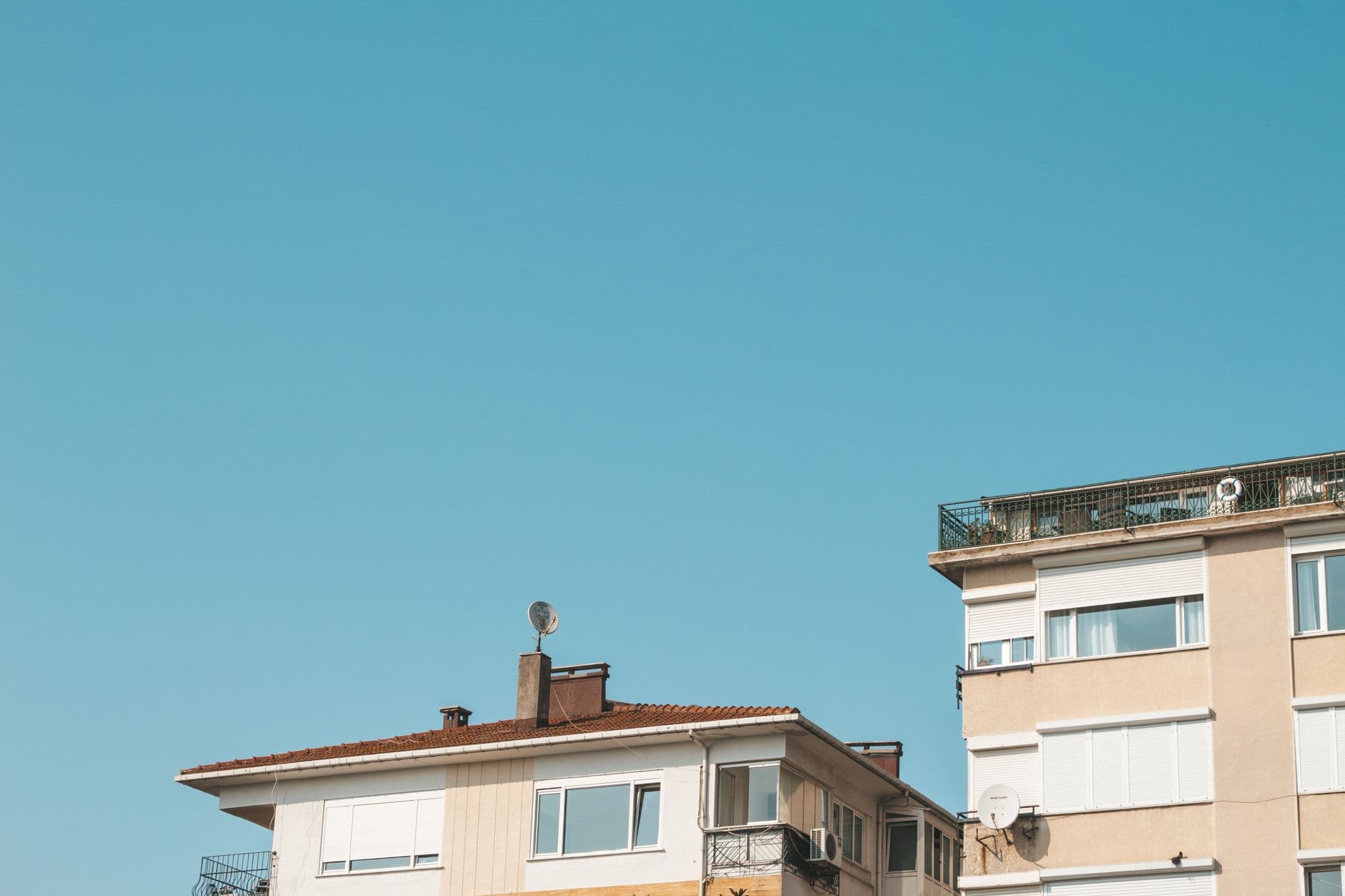 Low angle view of a contemporary building facade under a bright blue sky.